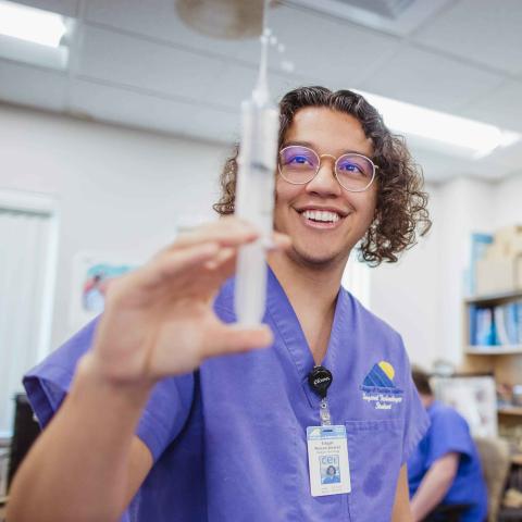 Nursing student holding syringe
