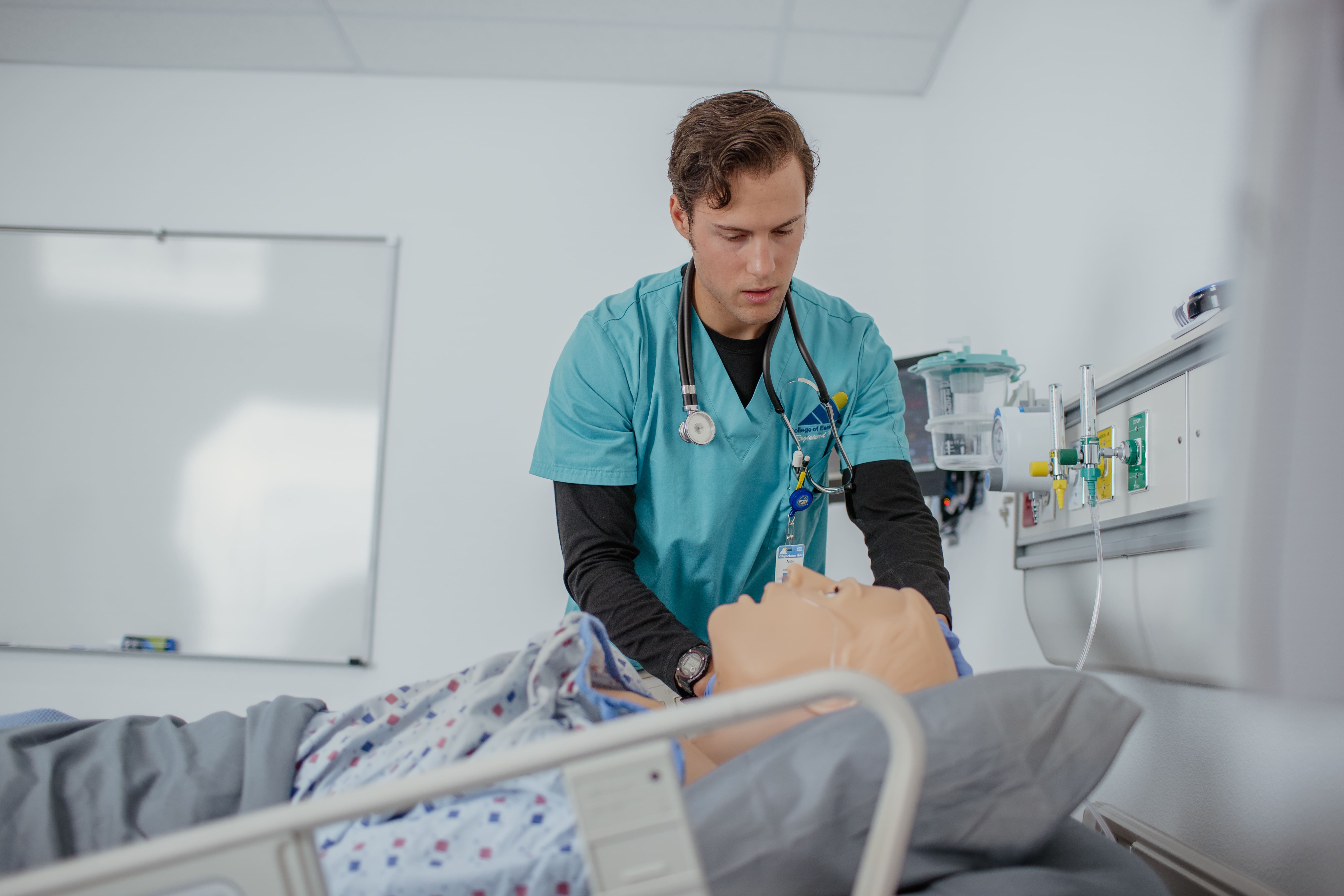 A nursing student practices health care with a dummy.